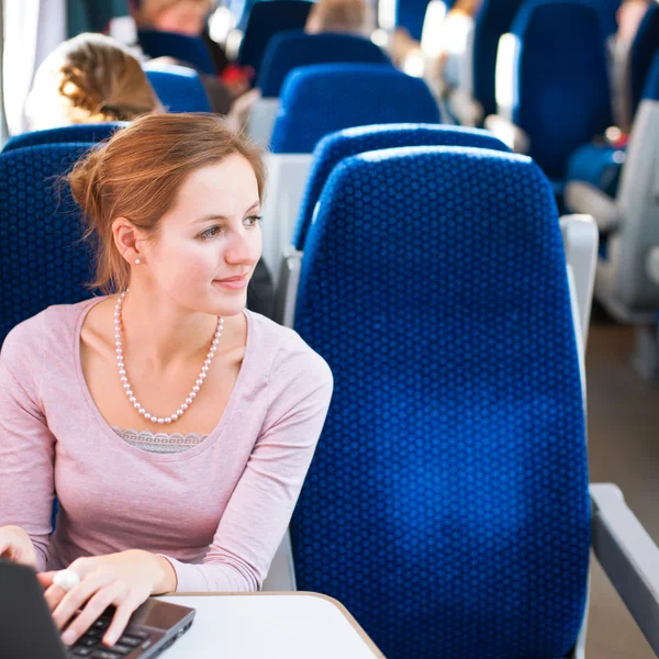 Young woman using her laptop computer while on the train — Stock Photo, Image
