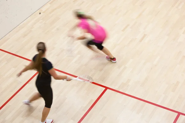 stock image Two female squash players in fast action on a squash court