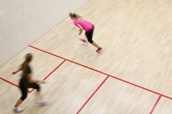 Due squash player femminili in azione veloce su un campo da squash — Foto Stock