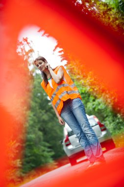 Young female driver calling the roadside service clipart