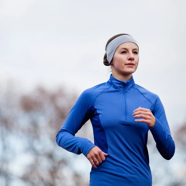 Portrét ženy běh proti proti modré obloze — Stock fotografie