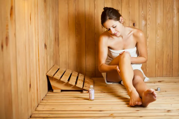 Jeune femme relaxante dans un sauna — Photo
