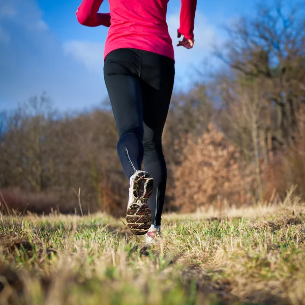 Mujer joven corriendo al aire libre en un parque de la ciudad en una caída fría —  Fotos de Stock