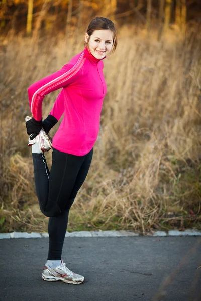 Genç bir kadın onun Koşudan önce germe — Stok fotoğraf