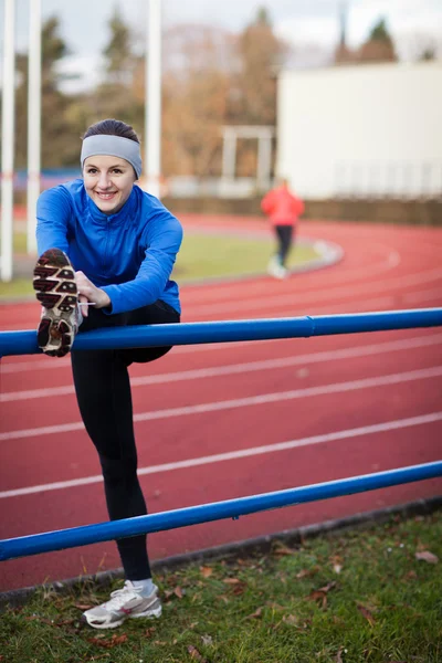 Young woman stretching before her run — Stock Photo, Image