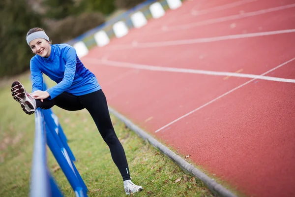 Joven mujer estirándose antes de su carrera — Foto de Stock