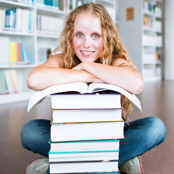 Estudante universitário muito feminino em uma biblioteca — Fotografia de Stock
