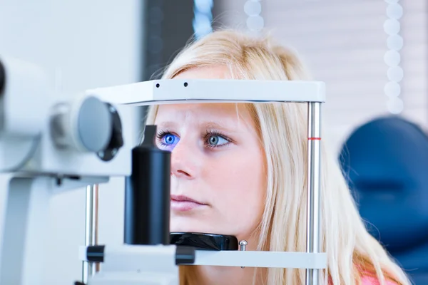 Mooie, jonge vrouwelijke patiënt met haar ogen onderzocht — Stockfoto