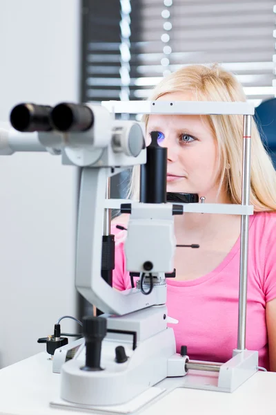 Mooie, jonge vrouwelijke patiënt met haar ogen onderzocht — Stockfoto