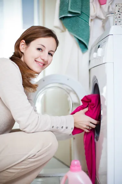 Házimunka: fiatal nő csinál mosoda — Stock Fotó