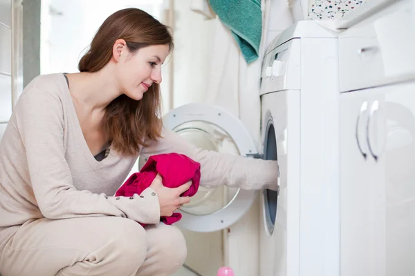 Prace domowe: młoda kobieta robi pranie — Zdjęcie stockowe