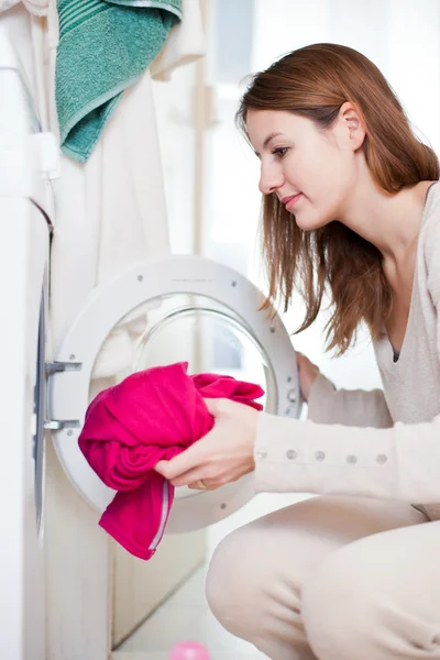 Hushållsarbete: ung kvinna gör tvätt — Stockfoto