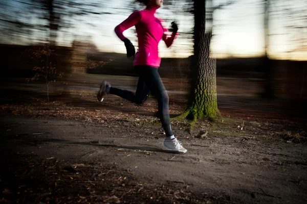 Giovane donna che corre all'aperto in un parco cittadino — Foto Stock