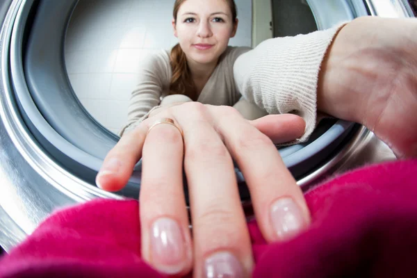 Робота вдома: молода жінка займається пранням — стокове фото