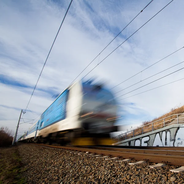 Spěšný vlak, procházející pod mostem na krásný letní den — Stock fotografie