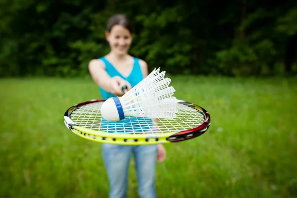 Bonita, jovem mulher jogando badminton em um parque da cidade — Fotografia de Stock