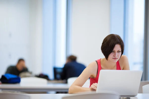Pretty young college student studying in the library — Stock Photo, Image
