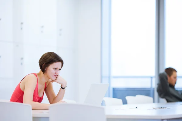 Vrij jonge college student studeert in de bibliotheek — Stockfoto