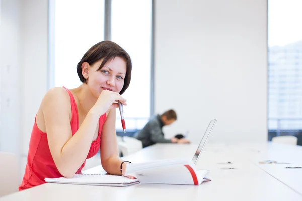 Pretty young college student studying in the library — Stock Photo, Image