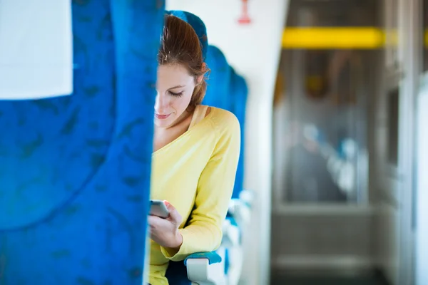 Молодая женщина, путешествуя на поезде, пользуется планшетным компьютером — стоковое фото