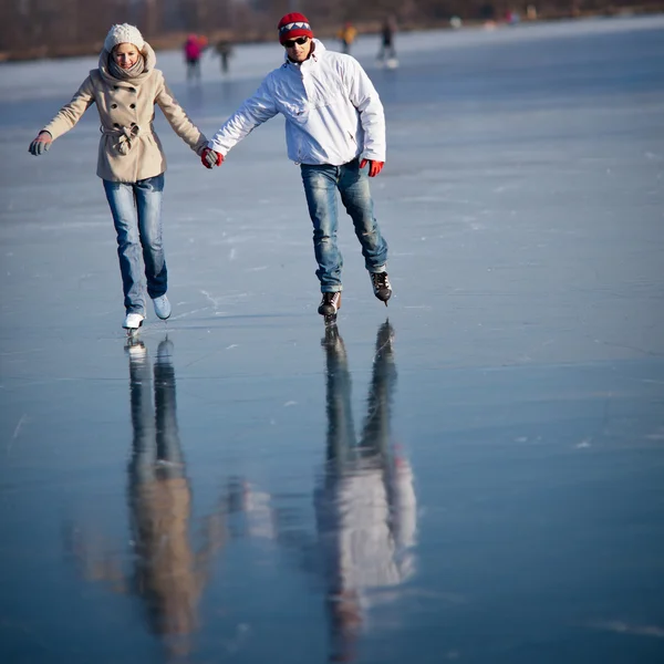 Couple patiner en plein air sur un étang par une belle journée ensoleillée d'hiver — Photo