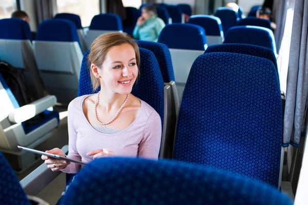 Молода жінка використовує свій планшет у потязі — стокове фото