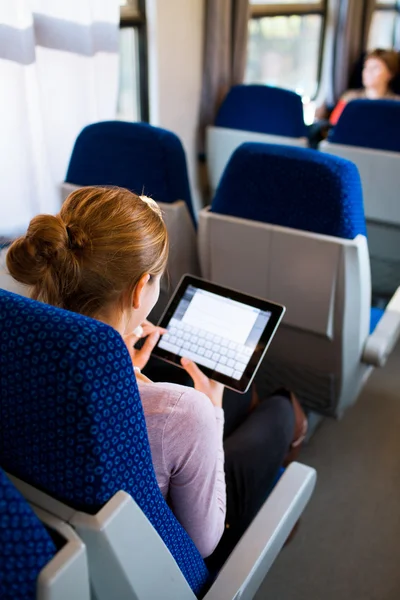 Молодая женщина, использующая планшет в поезде — стоковое фото
