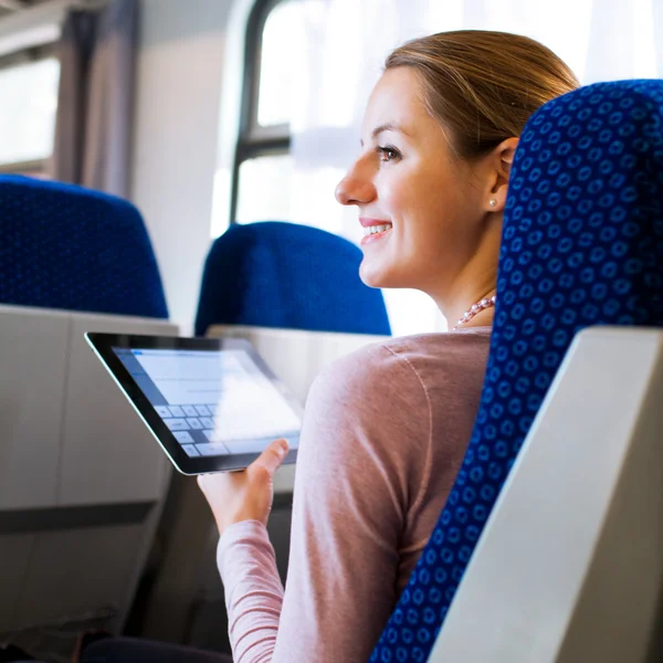 Jonge vrouw met behulp van haar Tablet PC in de trein — Stockfoto