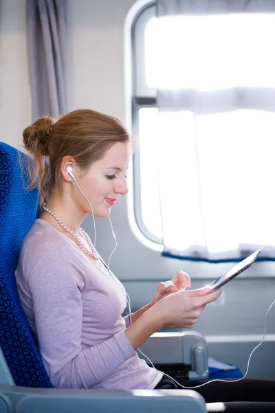 Młoda kobieta za pomocą jej tabletki w pociągu — Zdjęcie stockowe