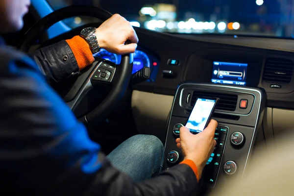 Man driving his modern car at night in a city — Stock Photo, Image