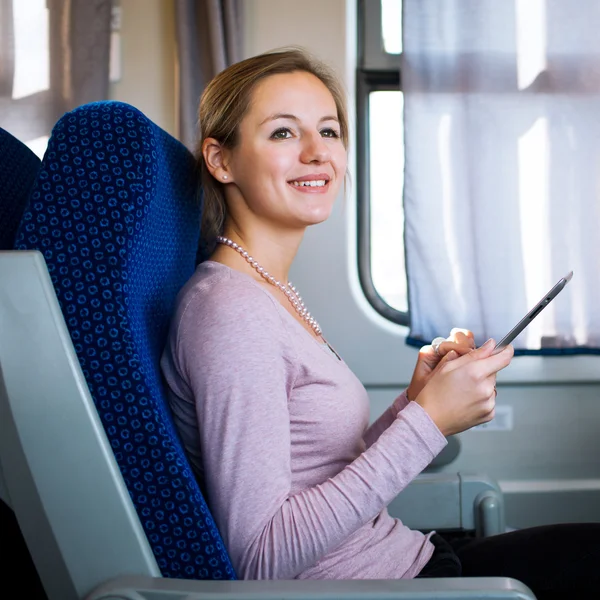 Νεαρή γυναίκα χρησιμοποιώντας το δισκίο σε τρένο — Φωτογραφία Αρχείου