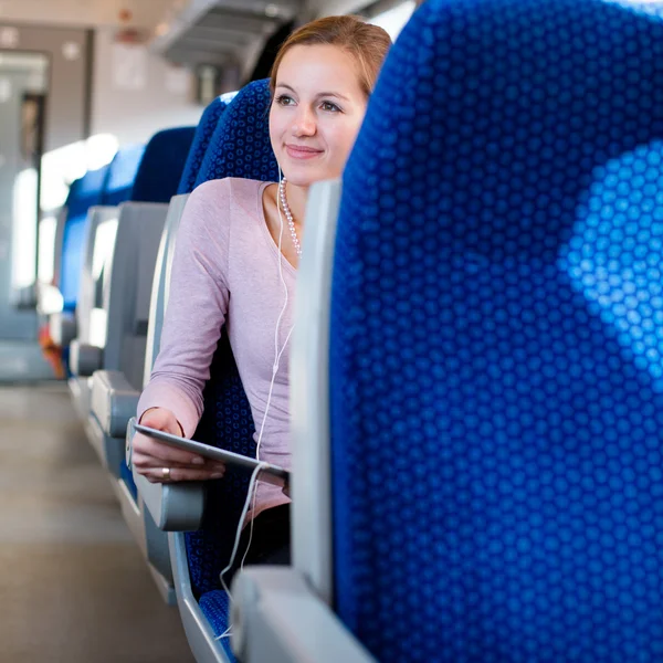 Mujer joven usando su tableta en tren — Foto de Stock