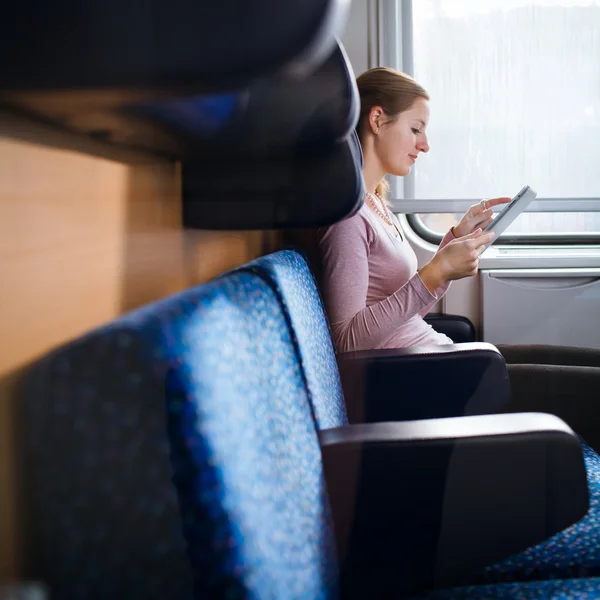 Mladá žena pomocí její tablet ve vlaku — Stock fotografie
