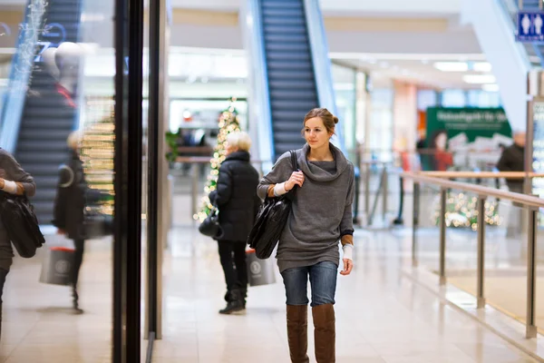 Young woman looking at store windows — Stock Photo, Image