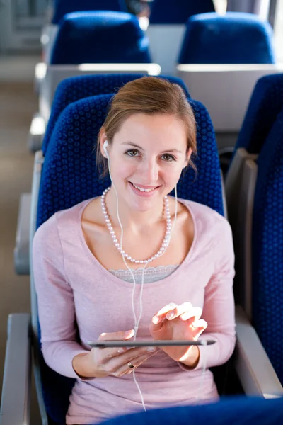 Young woman using her tablet in train Stock Photo