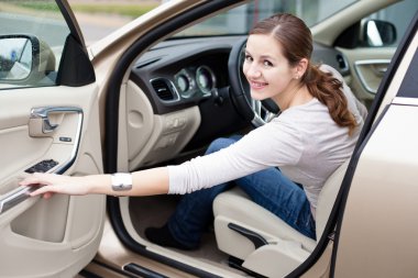 Pretty young woman driving her new car clipart