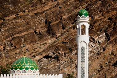 White mosque with minaret against rocky background (Muscat, Oman clipart