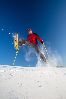 genç adam açık havada snowshoeing yaparken eğlenmek