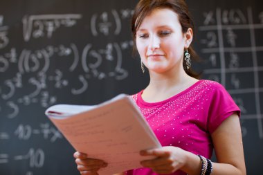 Student by the blackboard during a math class clipart