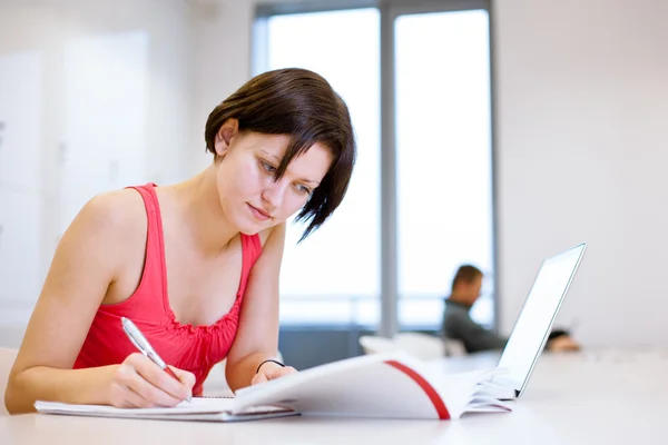 Vrij jonge college student studeert in de bibliotheek — Stockfoto