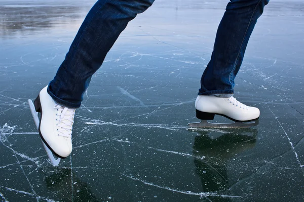 Jonge vrouw ijs schaatsen buitenshuis op een vijver op een ijskoude winter — Stockfoto