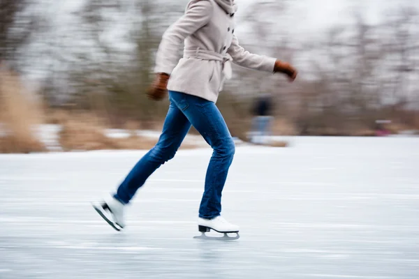 Junge Frau beim Eislaufen im Freien auf einem Teich — Stockfoto