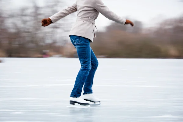 Giovane donna pattinaggio su ghiaccio all'aperto su uno stagno — Foto Stock
