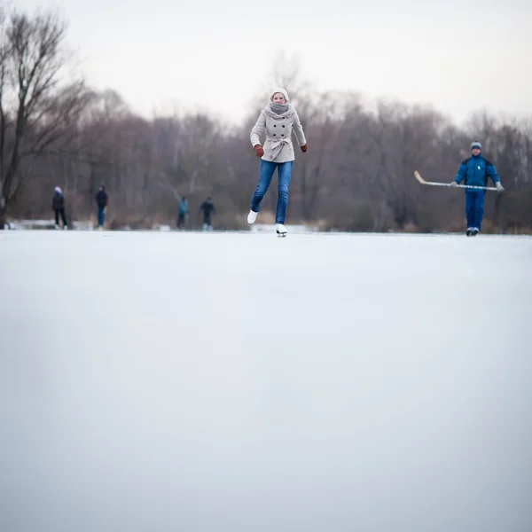 Jonge vrouw schaatsen buiten op een vijver — Stockfoto