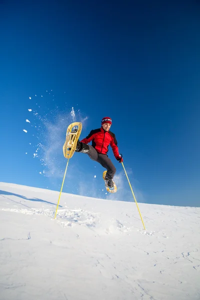 Mladý muž baví zároveň sněžnice venku — Stock fotografie