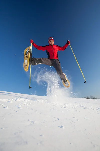 Jovem se divertindo enquanto snowshoeing ao ar livre — Fotografia de Stock