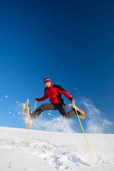 Ung man ha roligt medan snöskor utomhus — Stockfoto