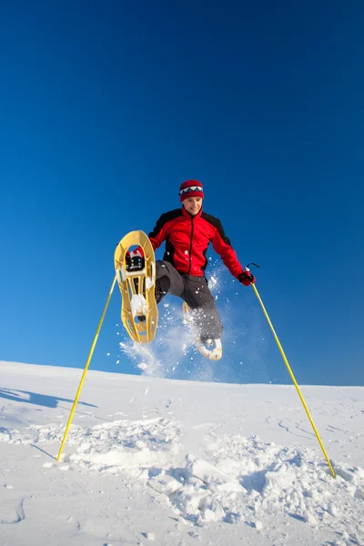 Genç adam açık havada snowshoeing yaparken eğlenmek — Stok fotoğraf