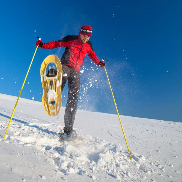 Genç adam açık havada snowshoeing yaparken eğlenmek — Stok fotoğraf