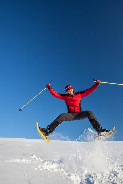 Junger Mann hat Spaß beim Schneeschuhwandern im Freien — Stockfoto